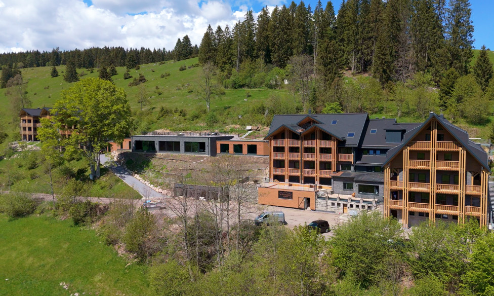 Außenansicht der Black Forest Lodge mit vielen Holzelementen und schön gelegen am grünen Hang