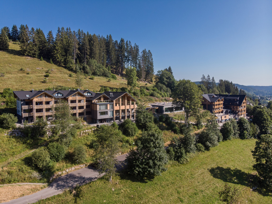 Blick auf den grünen Südhang des Feldbergs mit der Black Forest Lodge