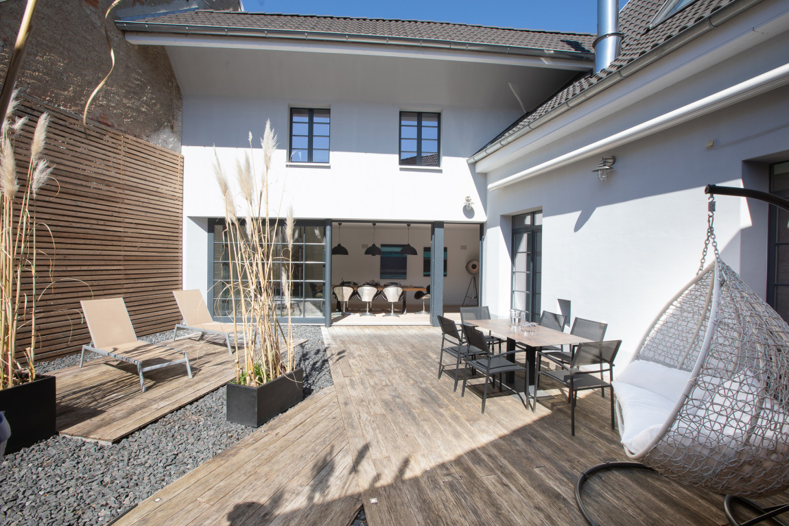 Blick auf die Terrasse mit Gartenmöbeln und Chill-Sessel