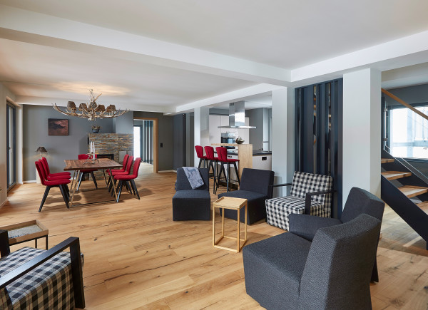 Blick in den WOhnbereich des APartments mit stylischen Möbeln in schwarz, weiß und rot. Dazu passende Deko im Schwarzwald-Look